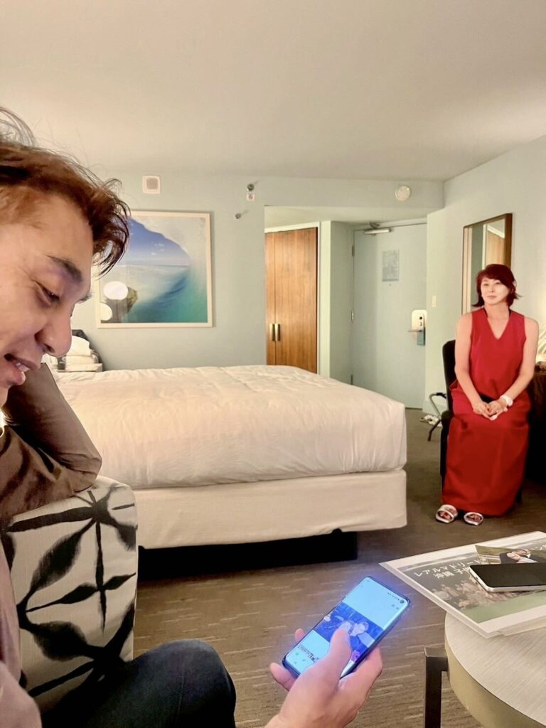 スマートフォンで出会った頃の写真を探す田場裕也さんと山田美加子さん
