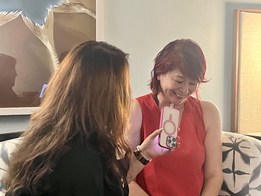 スマートフォンを見ながら微笑む山田美加子さん